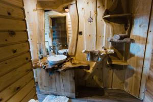 La salle de bains est pourvue d'un lavabo dans une cabane en rondins. dans l'établissement Forest Glade Cottage - Koča na jasi, à Rečica ob Savinji