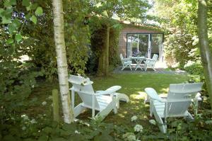 a group of white chairs and a table in a yard at Vita Nova in Hippolytushoef +23 photos