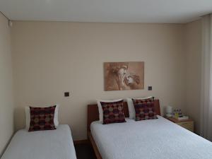 a hotel room with two beds and a painting on the wall at Next to the Airport in Moreira
