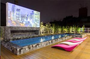 a large screen on the side of a building with a pool at Studio Augusta in Sao Paulo
