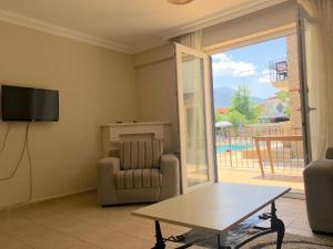 a living room with a tv and a couch and a table at Dove Apart Hotel in Fethiye