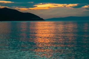 a sunset over a large body of water at By the sea luxury suites in Limenas
