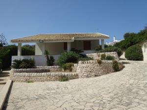 a house with a stone walkway and a stone wall at Villa Linda on the sea in Siracusa