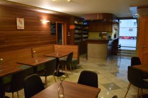 a restaurant with wooden tables and chairs and a counter at Natural Panzió in Győr