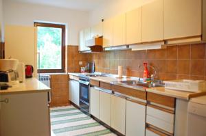 eine große Küche mit weißen Schränken und einem Fenster in der Unterkunft Spacious Apartment in quiet surrounding in Ičići
