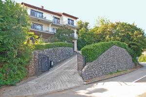 a stone fence with a gate in front of a building at Spacious Apartment in quiet surrounding in Ičići