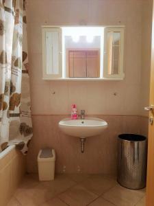 W łazience znajduje się umywalka i lustro. w obiekcie Centrum - A. Apartman w mieście Pecz