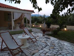 a patio with chairs and a table on a stone patio at Eftihias house in Kefallonia