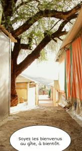 a tree with a sign that says squeeze less yourselves all grief and benefit at Gîte Village Paradise Valley in Tagherat Anekrim