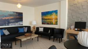 a living room with a couch and a tv at Marzi Boutique Hotel in Nerátza