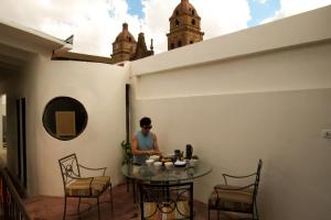 サンタ・クルス・デ・ラ・シエラにあるNomad Hostelのバルコニーのテーブルに座る男