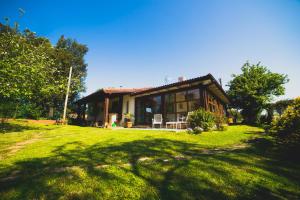 uma pequena casa num campo relvado à frente em Casa Candelas em Lugo de Llanera