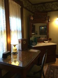 a room with a desk with a lamp and a mirror at Allen House Inn in Amherst