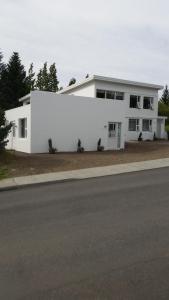 un edificio bianco sul lato di una strada di Lagarfell Studios a Egilsstadir