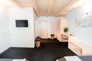 a room with white walls and a desk and a tv at Hotel House Rozka in Cerklje na Gorenjskem