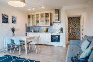 uma cozinha e sala de estar com mesa e cadeiras em Apartament Aqua Ustronie Morskie em Ustronie Morskie