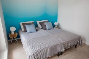 ウストロニエ・モルスキエにあるApartament Aqua Ustronie Morskieの青い壁のベッドルーム1室(大型ベッド1台付)