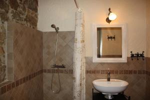 ein Badezimmer mit Dusche und Waschbecken in der Unterkunft Apartamentos El Jardín del Poeta in Guijo de Granadilla + 30 Fotos