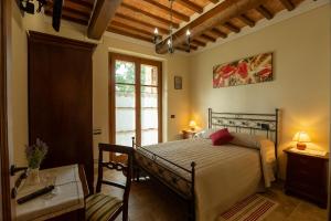 1 dormitorio con cama y ventana en Borgo Poggiardelli en Montepulciano