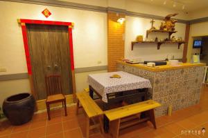 a kitchen with a table and a counter and a table and stool at Beigang Nice Stay in Beigang