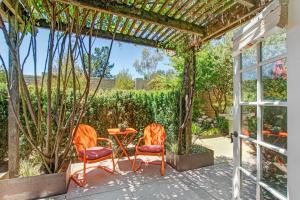2 sillas naranjas y una mesa en el patio en Bungalows 313, en Sonoma