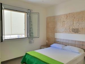 1 dormitorio con cama y ventana en Blu Maris Sicilia Guesthouse, en Marina di Ragusa