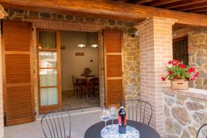 einen Tisch mit zwei Weingläsern auf einer Terrasse in der Unterkunft Borgo Poggiardelli in Montepulciano