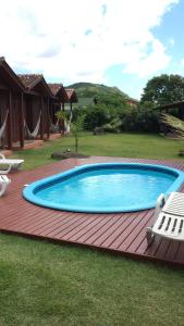 a swimming pool on a wooden deck next to a house at Green Mountain Pousada in Florianópolis