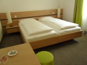 A bed or beds in a room at Gasthof-Pension Schütz