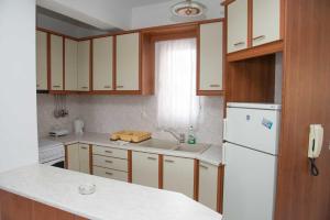 een keuken met witte kasten en een witte koelkast bij Hellenic Sun in Lassi