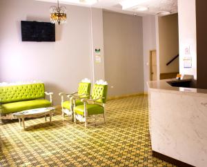 a waiting room with a green couch and chairs at Hotel Med Centro - Marcari in Barranquilla