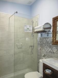 y baño con ducha, aseo y lavamanos. en Hostal los Aromas, en Villena
