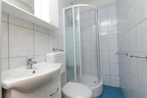 a bathroom with a toilet and a sink and a shower at Apartments and Room Mate-Mare in Primošten