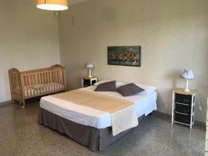 a bedroom with a large bed and a crib at Appartamenti in Villa incanto dei trabocchi Un gioiello esclusivo tra mare e natura in Treglio