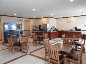 a kitchen with a table, chairs and a refrigerator at Sierra Inn Minot in Minot
