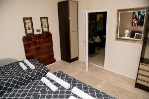 a bedroom with a black and white bed and a mirror at Apartments Cvetkovic Relax in Niška Banja