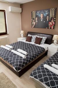 a bedroom with a large bed with black and white sheets at Apartments Cvetkovic Relax in Niška Banja