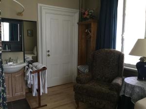 a bathroom with a chair and a sink at Gil Ann in Saint-André-Avellin