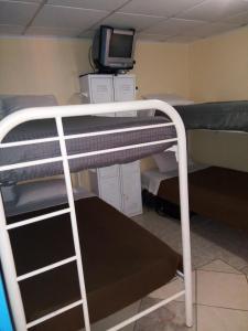 a bunk bed with a desk and a tv at Hostel Room Aruba in Oranjestad