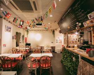 una sala da pranzo con tavoli, sedie e bandiere di Sakura Hotel Jimbocho a Tokyo