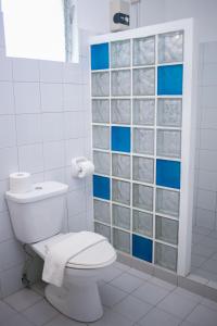 a bathroom with a toilet and blue and white tiles at Blue Star Dive and Resort in Anda