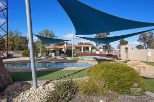 a blue umbrella over a pool in a yard at Horsham Holiday Park in Horsham