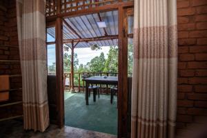 a screened in porch with a table and a view at Apurvi Homestay in Ella