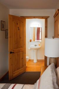 a bathroom with a wooden door and a sink at Rock Hill Bed & Breakfast in Sharbot Lake