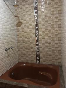 La salle de bains est pourvue d'une baignoire brune et d'une douche. dans l'établissement Hotel Manantial No,002, à Lima