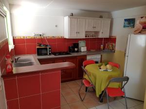 una pequeña cocina con mesa y nevera en Bel Appartement - proche des plages de Sainte Anne, en Sainte-Anne