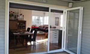 a sliding glass door leading into a dining room with a table at Peachgrove in Hamilton