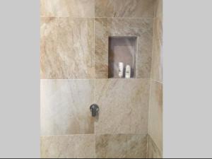 uma casa de banho com um chuveiro e uma cabina de duche em pedra. em Bijoux Beach House em Freshwater