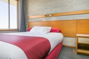 
a bed in a bedroom with a white bedspread at Nullarbor Roadhouse in Nullarbor
