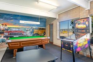 een kamer met een pooltafel en een arcadespel bij Nullarbor Roadhouse in Nullarbor
